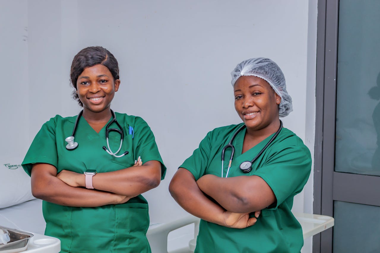 my-path Two female nurses in green scrubs smiling confidently in a hospital room. Professional healthcare workers.